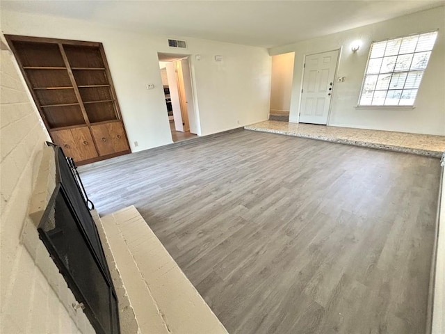 unfurnished living room with visible vents and wood finished floors