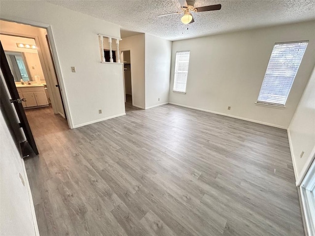 spare room with baseboards, a textured ceiling, a ceiling fan, and wood finished floors