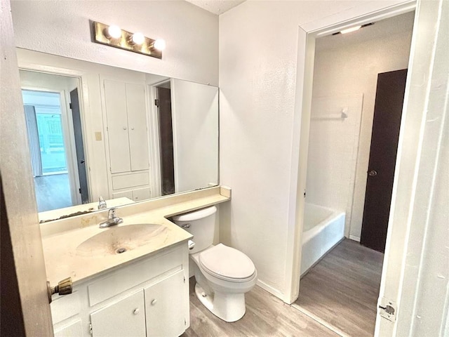 full bath featuring vanity, wood finished floors, toilet, and baseboards