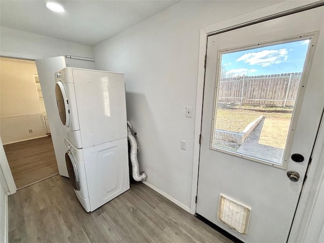 laundry room featuring stacked washer and dryer, laundry area, visible vents, and light wood-style floors