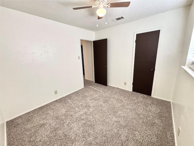 unfurnished bedroom with baseboards, visible vents, a ceiling fan, a textured ceiling, and carpet flooring