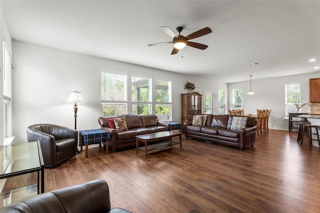 living room featuring dark wood-style flooring, recessed lighting, a ceiling fan, and a healthy amount of sunlight