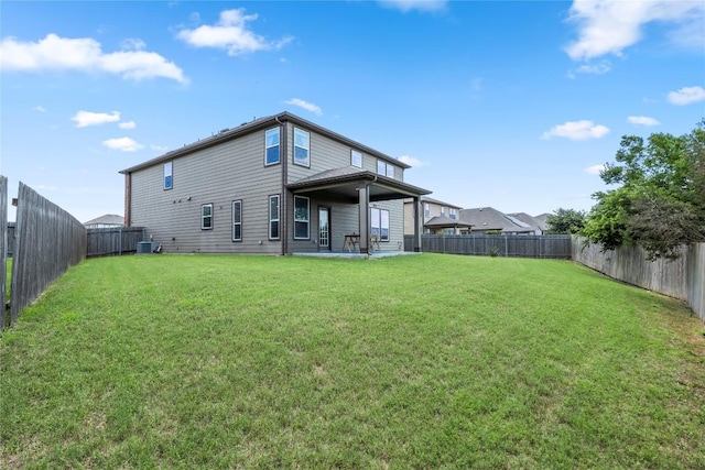 rear view of property featuring a lawn and a fenced backyard