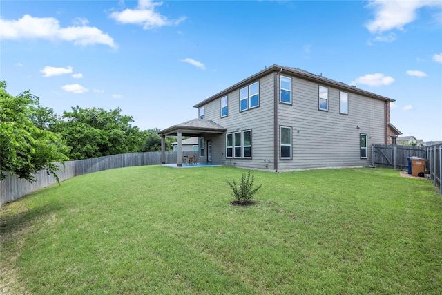 back of property with a patio area, a lawn, and a fenced backyard