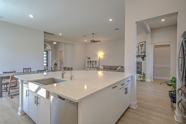 kitchen featuring recessed lighting, light wood-style flooring, appliances with stainless steel finishes, white cabinetry, and a sink