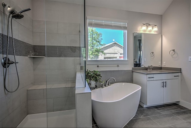 bathroom featuring a tile shower, a freestanding bath, and vanity