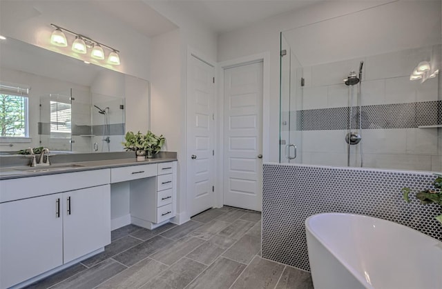 full bath featuring a freestanding bath, a shower stall, and vanity