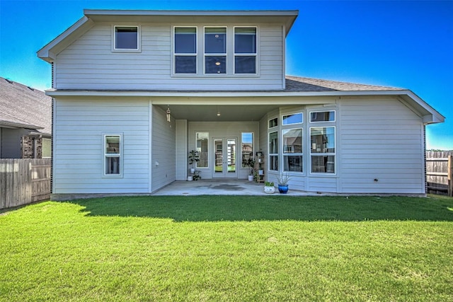 back of property with a patio, french doors, a lawn, and fence