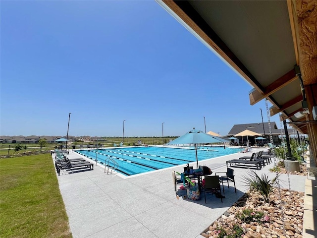 view of pool featuring a lawn