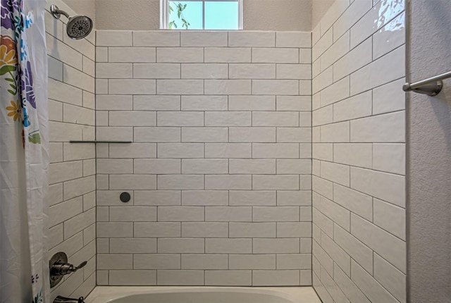 full bathroom featuring a textured wall and shower / bathtub combination with curtain