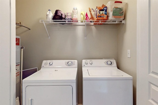 washroom with water heater, laundry area, and washer and clothes dryer