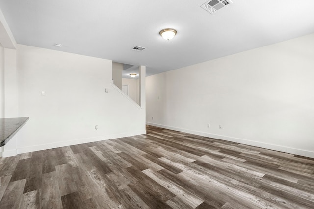 interior space featuring baseboards, visible vents, and dark wood-type flooring