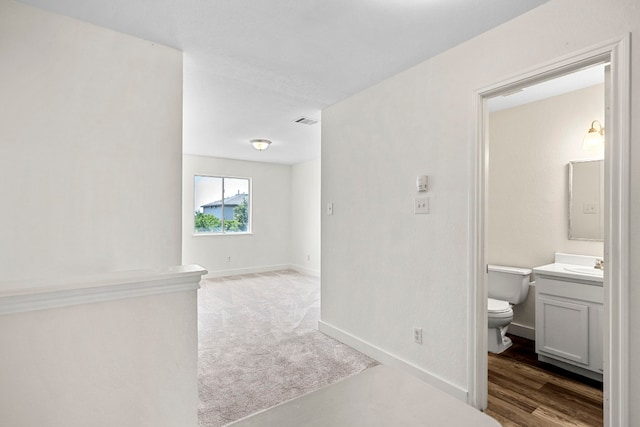 interior space with visible vents, vanity, toilet, and baseboards