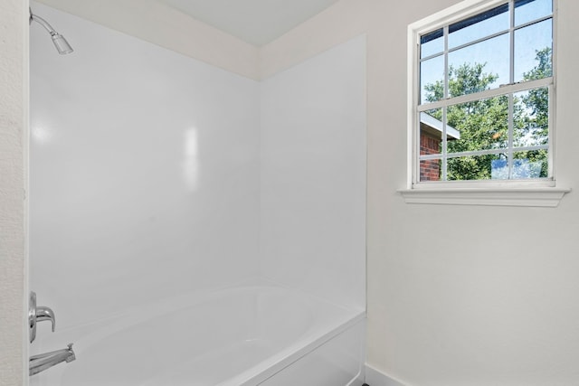 full bathroom with washtub / shower combination and baseboards