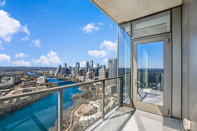 balcony featuring a water view and a city view