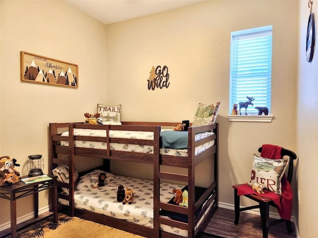 bedroom featuring wood finished floors and baseboards