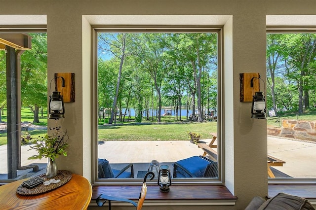 doorway with a healthy amount of sunlight, a water view, and a textured wall