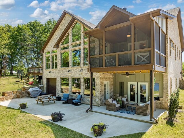 rear view of property with a patio, driveway, and an outdoor hangout area