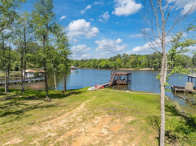 view of dock with a water view and a lawn