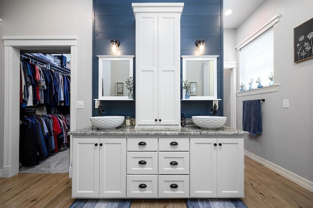 interior space featuring wood finished floors, a sink, and double vanity