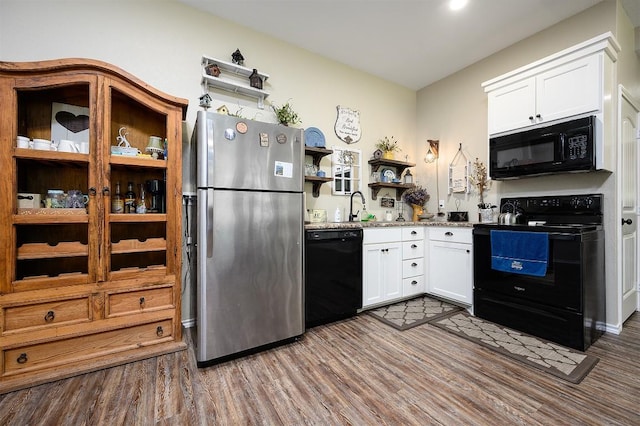 kitchen featuring white cabinets, wood finished floors, black appliances, open shelves, and a sink