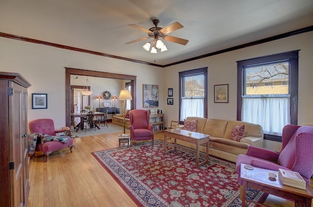 living area featuring ornamental molding, a ceiling fan, and light wood-style floors