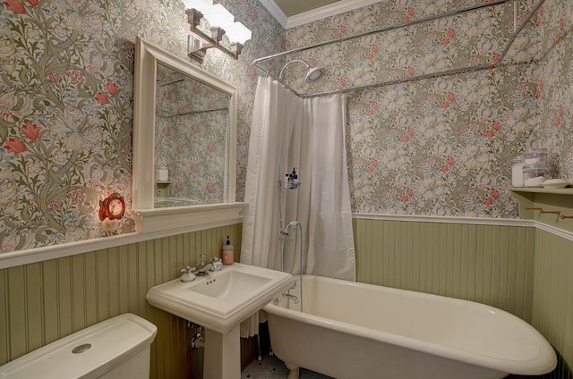 bathroom with curtained shower, a wainscoted wall, a freestanding bath, and wallpapered walls