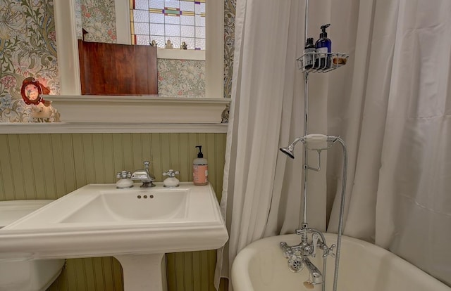 full bathroom featuring a washtub and a sink