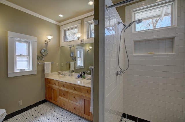 bathroom with recessed lighting, vanity, baseboards, a tile shower, and crown molding