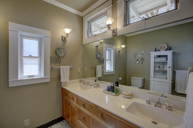 full bathroom featuring double vanity, a sink, toilet, and crown molding