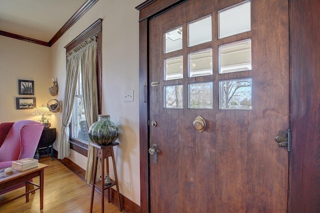 doorway to outside with light wood-style floors, crown molding, and baseboards