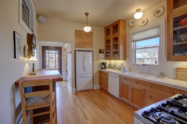 kitchen with white appliances, a healthy amount of sunlight, a sink, and decorative backsplash