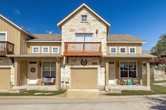 townhome / multi-family property with board and batten siding, covered porch, a balcony, and a standing seam roof