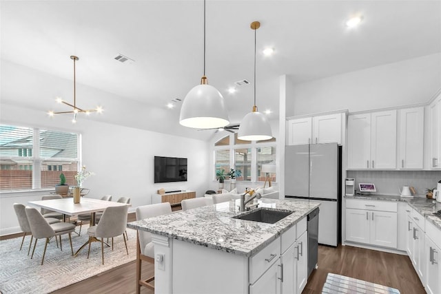 kitchen with a kitchen island with sink, dark wood finished floors, a sink, and visible vents