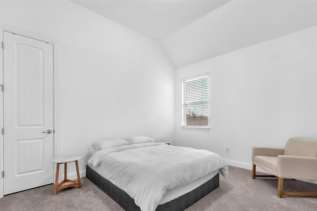 carpeted bedroom with lofted ceiling and baseboards