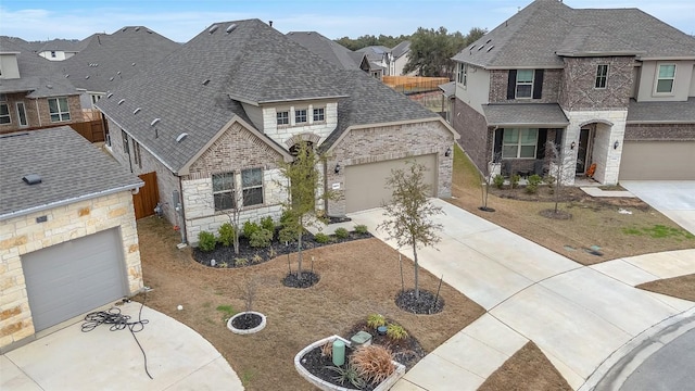 view of front of house with a garage, brick siding, a shingled roof, stone siding, and driveway