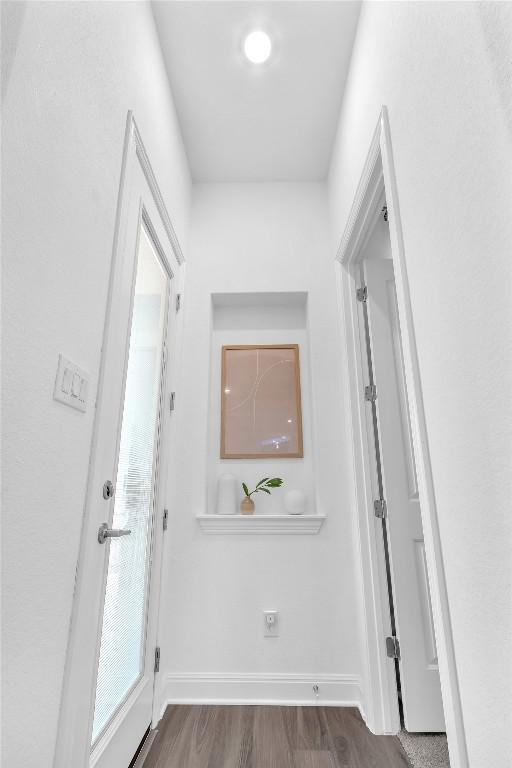 interior space featuring baseboards and dark wood-style flooring