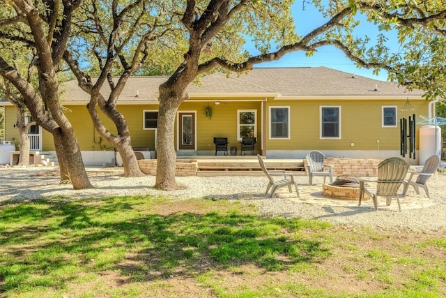 back of property with a patio area, a fire pit, and a lawn