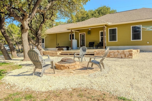 back of house featuring a patio, roof with shingles, and an outdoor fire pit