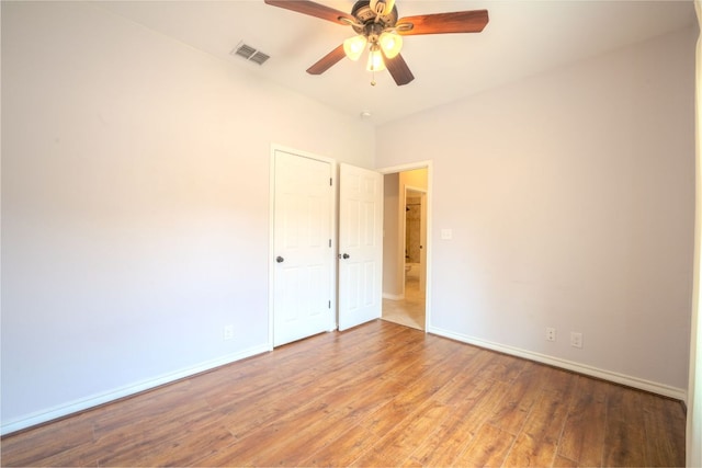 unfurnished room with visible vents, ceiling fan, baseboards, and hardwood / wood-style floors