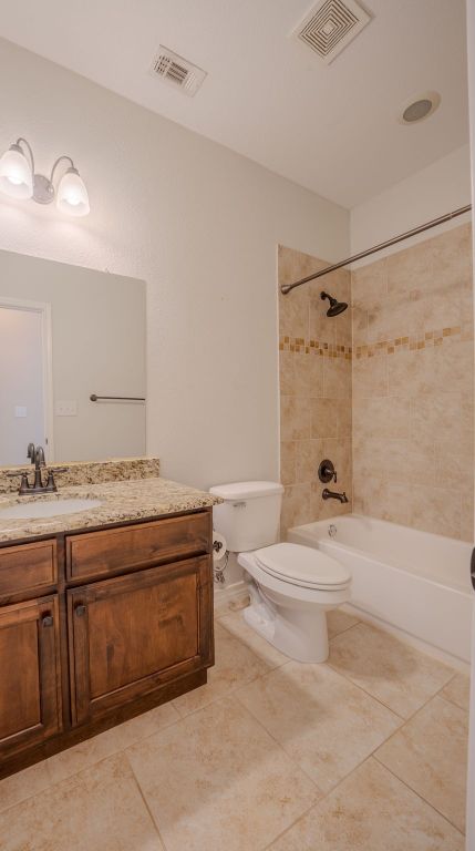 bathroom with visible vents, toilet, vanity, and tile patterned flooring