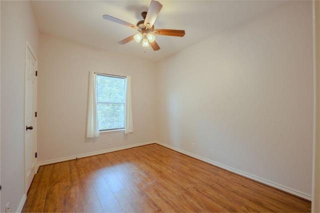 empty room featuring baseboards, a ceiling fan, and light wood-style floors