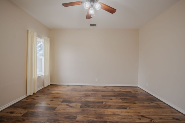 empty room with visible vents, baseboards, wood finished floors, and a ceiling fan