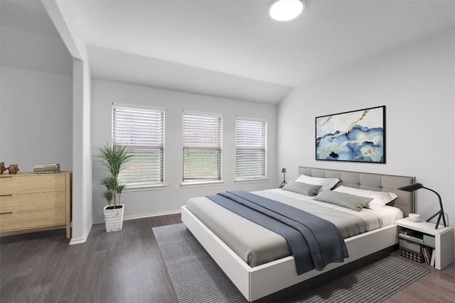 bedroom with lofted ceiling, wood finished floors, and baseboards