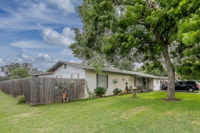 view of property exterior featuring a yard and fence