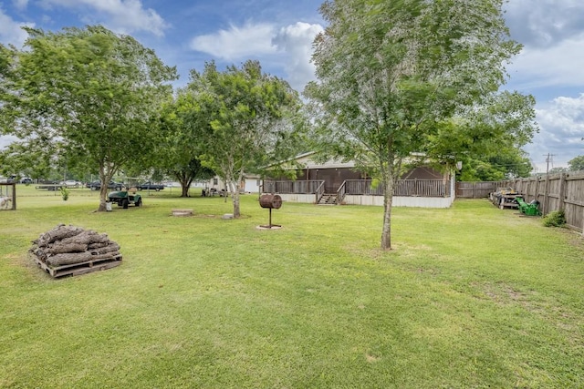 view of yard featuring a fire pit, a sunroom, and fence