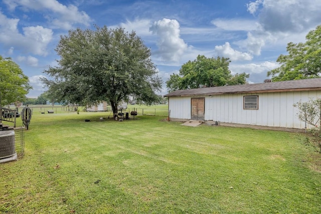 view of yard with central AC and fence