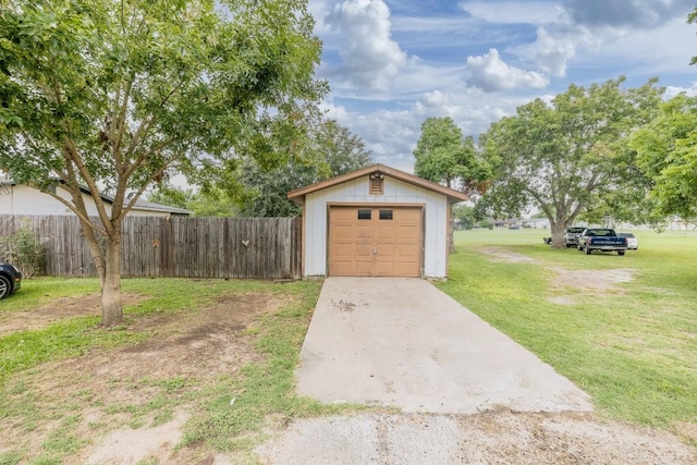 detached garage with fence and driveway