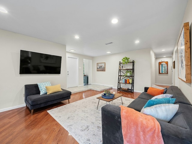 living area with baseboards, wood finished floors, visible vents, and recessed lighting