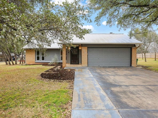 ranch-style house featuring metal roof, an attached garage, brick siding, driveway, and a front lawn